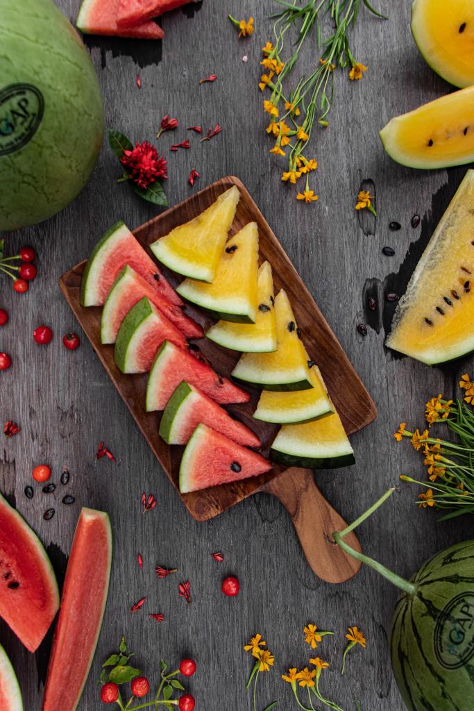 A colorful display of watermelons, showcasing the vibrant red and sunny yellow varieties side by side. The red watermelon has a deep crimson flesh, while the yellow watermelon reveals a golden hue. These refreshing summer fruits are perfect for beating the heat and enjoying a burst of sweet juiciness