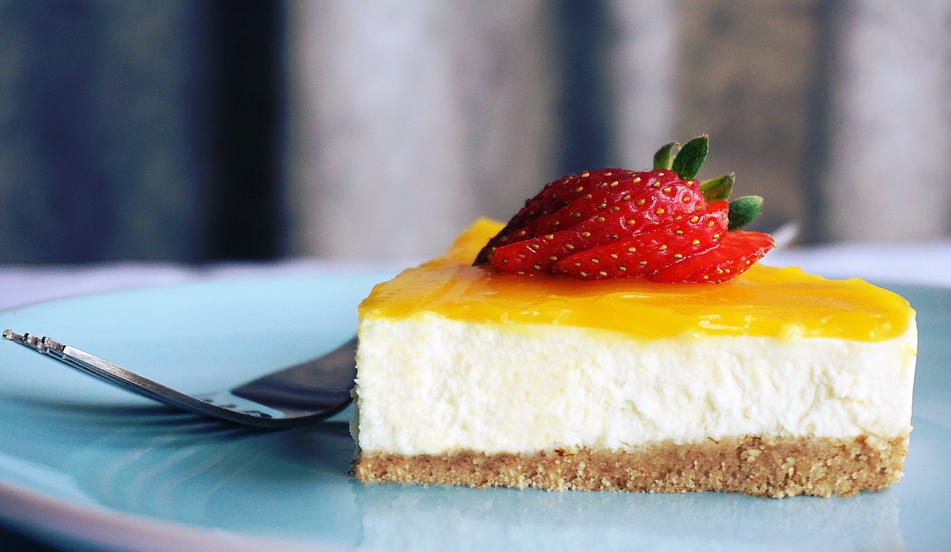 Classic cheesecake with a buttery graham cracker crust, served on a dessert plate.